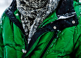 Green coat with snow on it